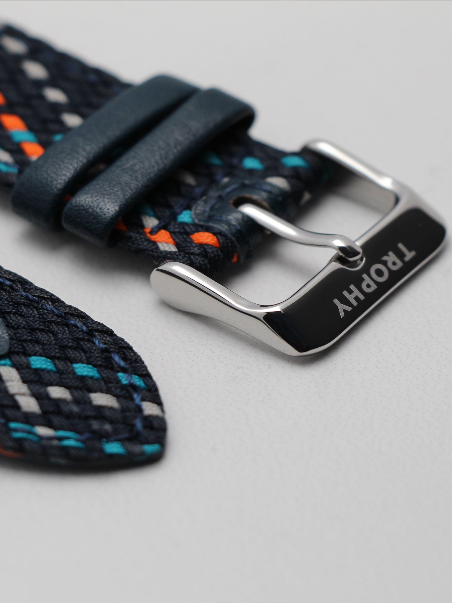 Trophy Watch Company | 40mm EMBERLINE PERLON: The Emerline Perlon brings an air of sporty sophisticaion to anyone who wears it. Truly unique in design and appearance, this watch makes a strong statement. The perlon strap has cords of navy blue, grey, teal